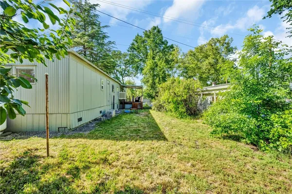 a view of a house with backyard and a tree