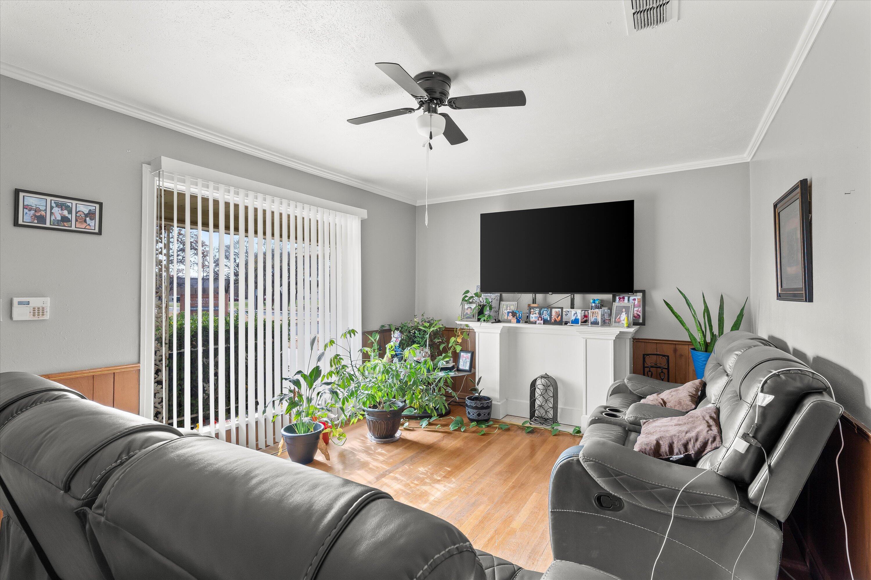 2222 22nd Street Lubbock, TX 79411 - Photo 4 of 16 a living room with furniture a flat screen tv and a fireplace