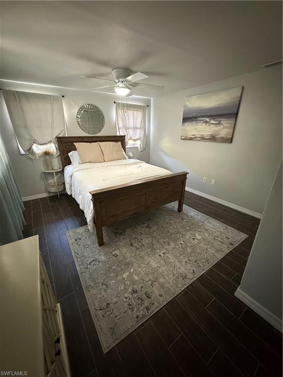 235 Cypress Way West Naples, FL 34110 - Photo 12 of 18 a bedroom with a bed and wooden floor