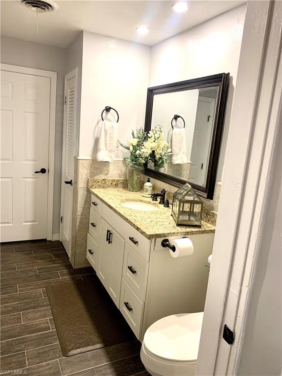 235 Cypress Way West Naples, FL 34110 - Photo 14 of 18 a bathroom with a sink vanity mirror and toilet