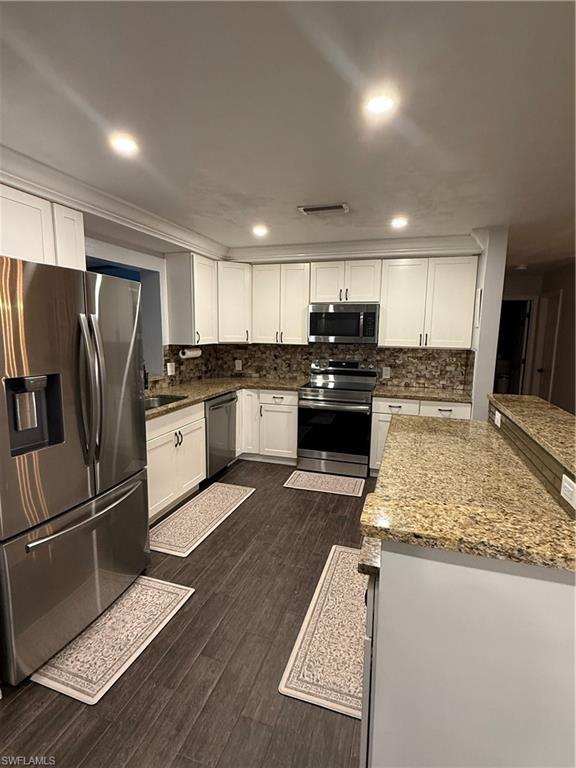 235 Cypress Way West Naples, FL 34110 - Photo 2 of 18 a kitchen with granite countertop a refrigerator and a stove top oven