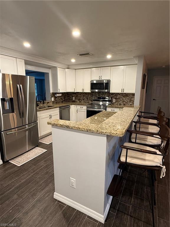 235 Cypress Way West Naples, FL 34110 - Photo 3 of 18 a kitchen with kitchen island a counter top space a stove a refrigerator and a sink