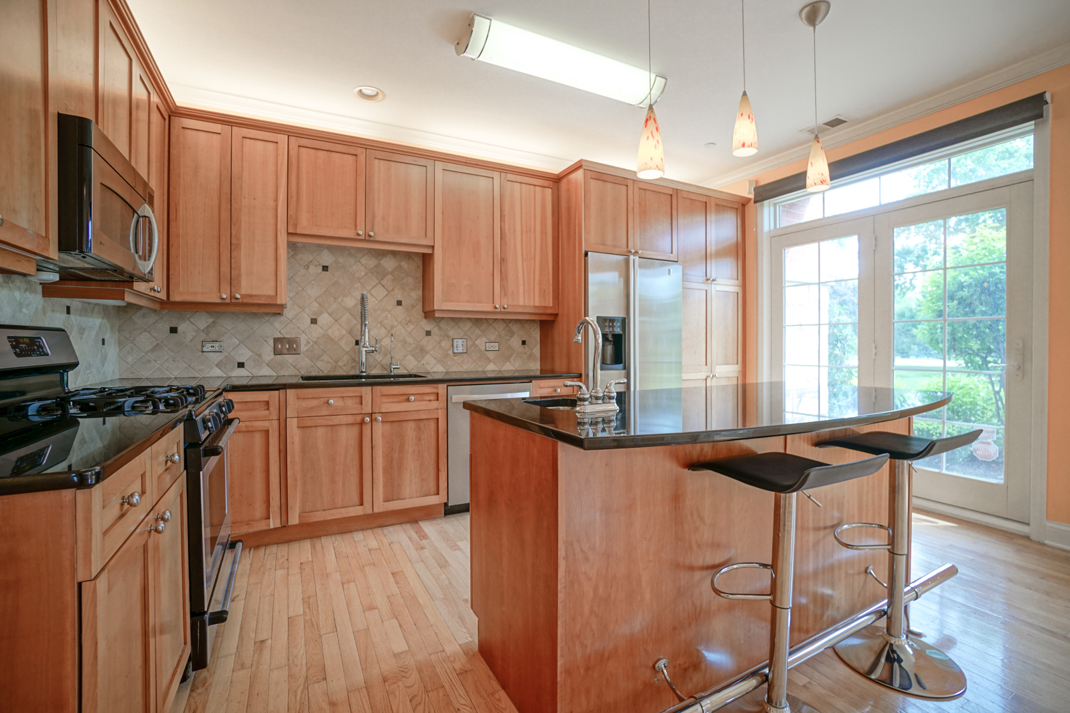 620 McHenry Road, Unit 105 Wheeling, IL 60090 - Photo 8 of 20 a kitchen with stainless steel appliances granite countertop a stove a sink dishwasher and a refrigerator with wooden floor