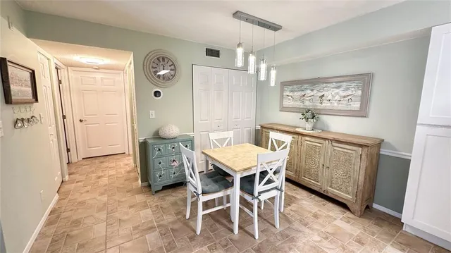 a kitchen with stainless steel appliances granite countertop a stove top oven a sink a dining table and chairs