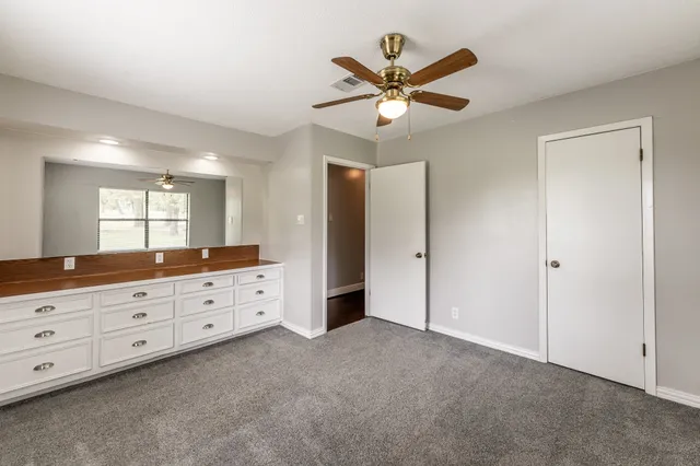 a very nice looking room with a large mirror and a ceiling fan
