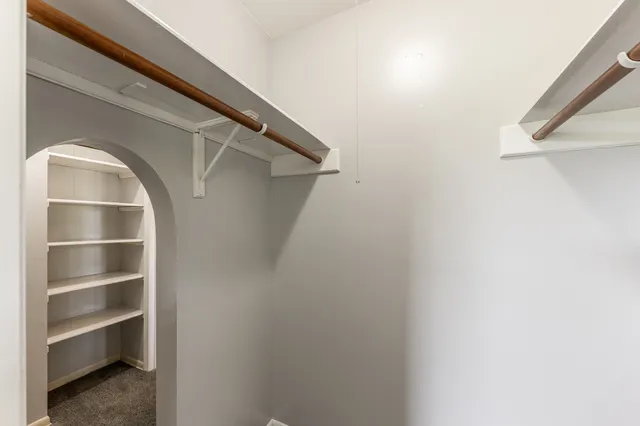 a view of walk in closet with empty racks