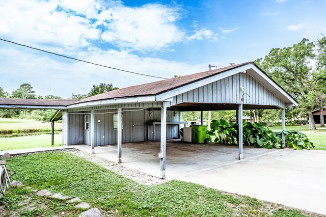 a backyard of a house with table and chairs under an umbrella