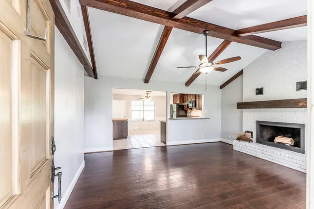 a view of a livingroom with wooden floor and a fireplace