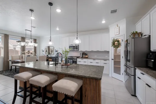 a kitchen with stainless steel appliances granite countertop sink stove refrigerator and cabinets