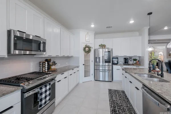 a large kitchen with stainless steel appliances granite countertop a stove a sink and a microwave