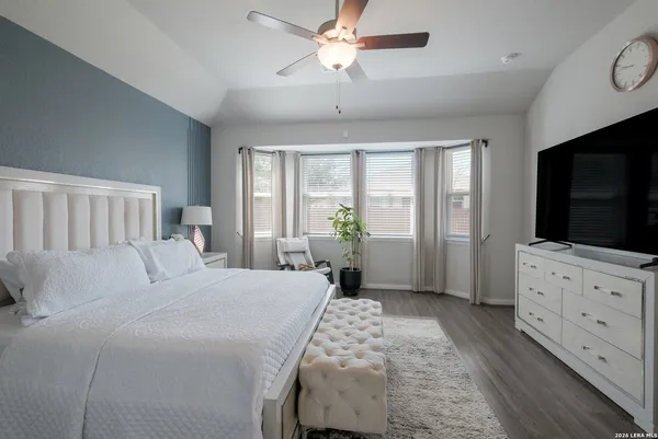 a bedroom with a large bed and a flat tv screen on dresser