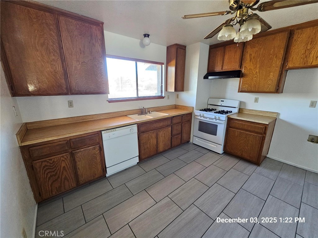 18891 Rock Springs Road Hesperia, CA 92345 - Photo 11 of 25 a kitchen with stainless steel appliances granite countertop a sink a stove and a microwave