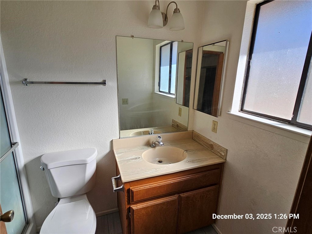 18891 Rock Springs Road Hesperia, CA 92345 - Photo 22 of 25 a bathroom with a toilet sink and mirror