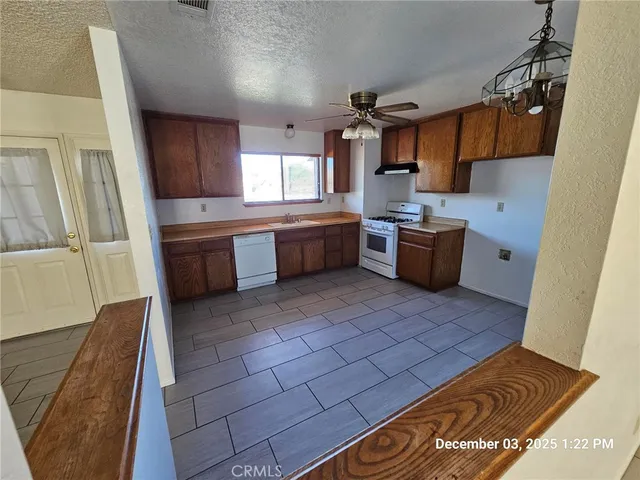a kitchen with stainless steel appliances granite countertop a sink a stove and a microwave