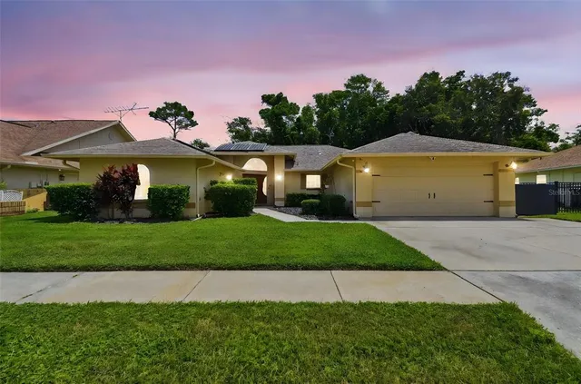 a front view of a house with a garden and yard