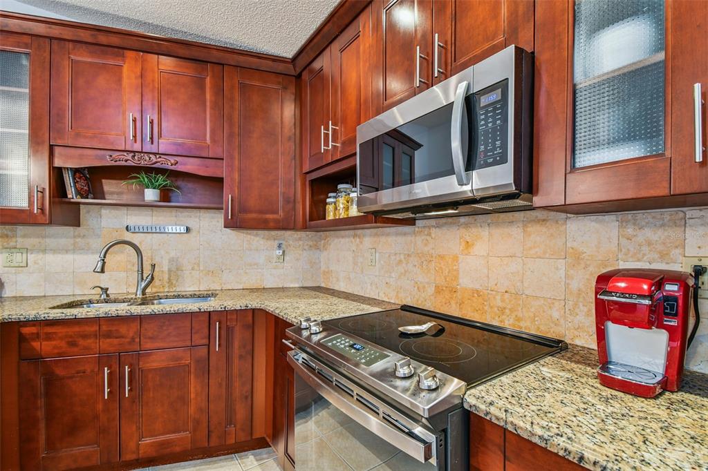 6006 Redhawk Drive New Port Richey, FL 34655 - Photo 21 of 90 a kitchen with stainless steel appliances granite countertop a stove and a sink