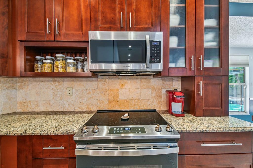 6006 Redhawk Drive New Port Richey, FL 34655 - Photo 22 of 90 a kitchen with granite countertop a stove and a microwave