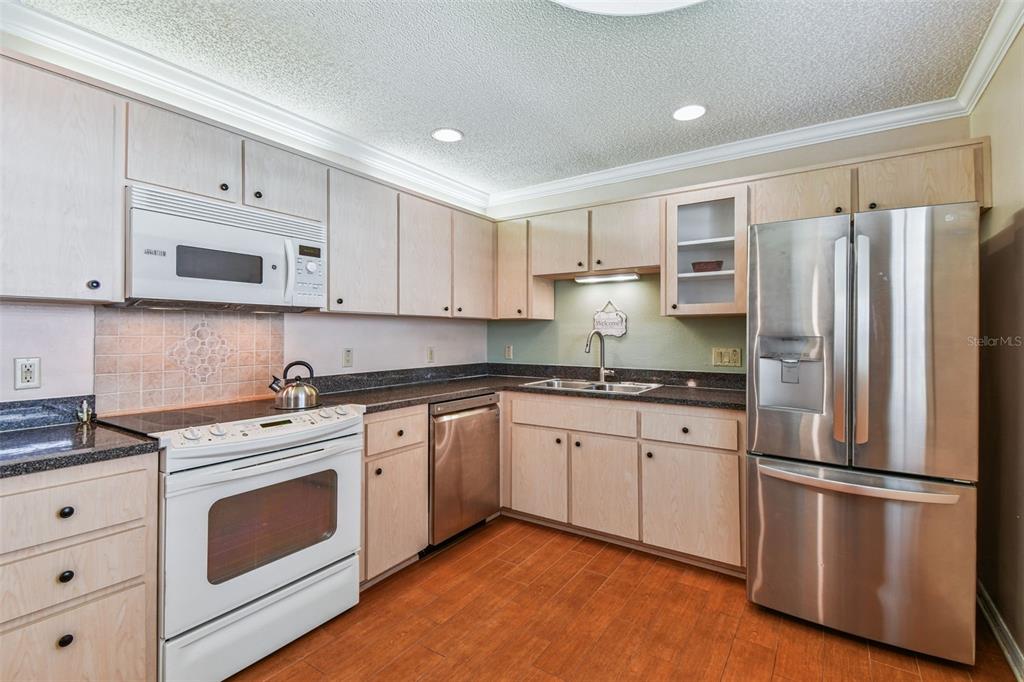 6006 Redhawk Drive New Port Richey, FL 34655 - Photo 48 of 90 a kitchen with stainless steel appliances granite countertop a refrigerator stove and white cabinets