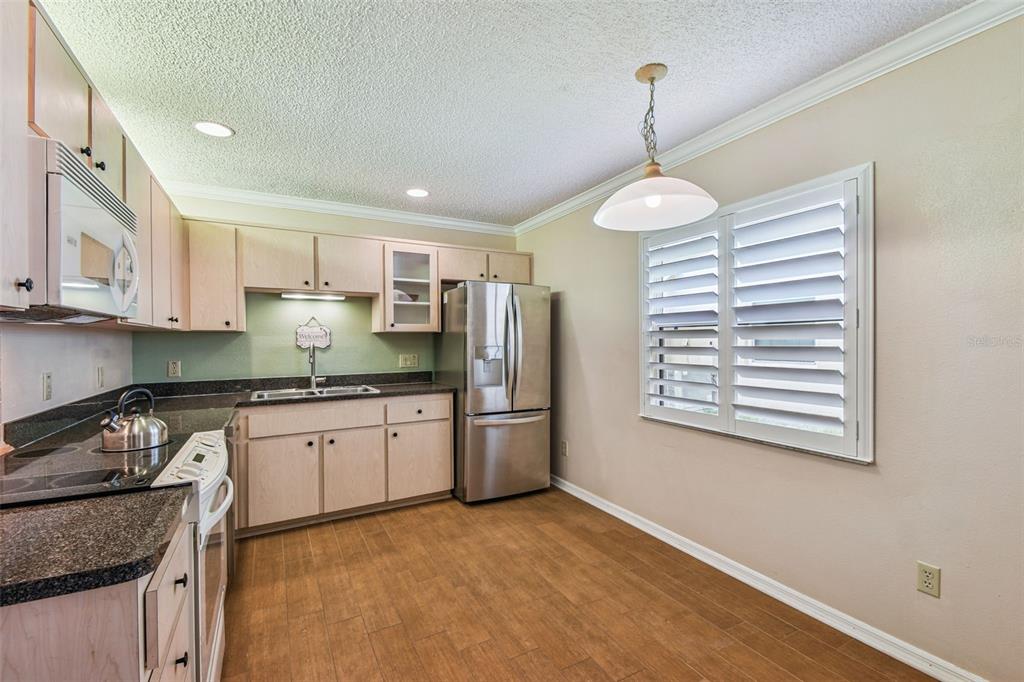 6006 Redhawk Drive New Port Richey, FL 34655 - Photo 52 of 90 a kitchen with stainless steel appliances granite countertop a sink stove and refrigerator