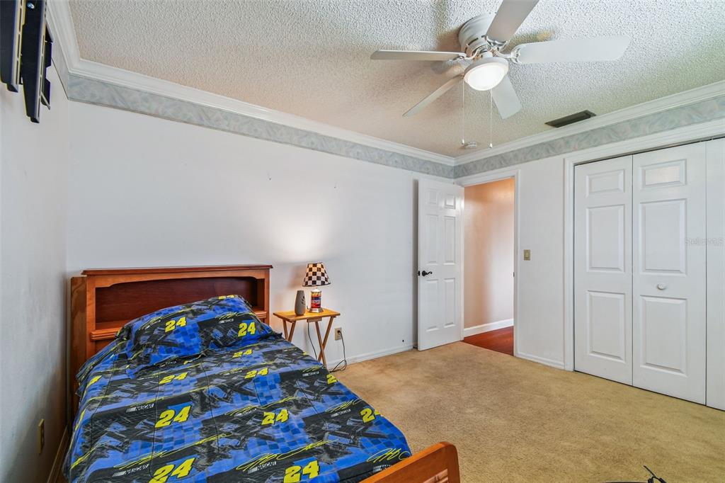 6006 Redhawk Drive New Port Richey, FL 34655 - Photo 63 of 90 a bedroom with a bed and a chandelier