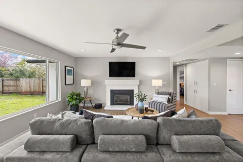 a living room with furniture a flat screen tv and a fireplace