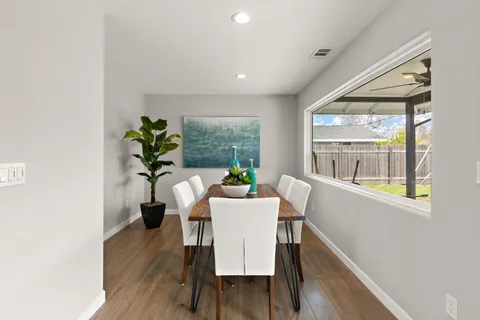 a dining room with furniture potted plants and wooden floor