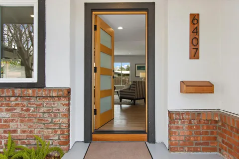a view of a hallway with wooden floor and a dining room