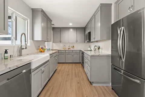 a kitchen with stainless steel appliances a refrigerator sink and cabinets