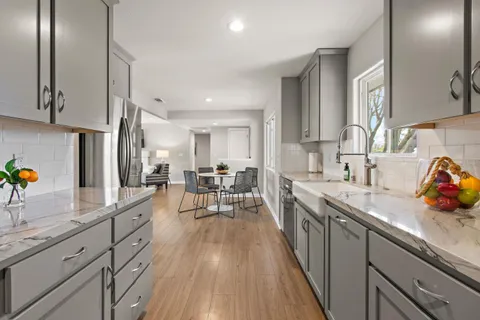 a kitchen with granite countertop a sink stove and cabinets