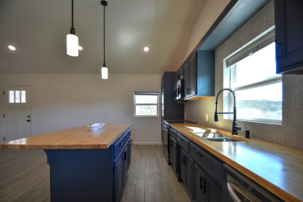 110 A Garner Road Kerrville, TX 78028 - Photo 11 of 46 a kitchen with stainless steel appliances granite countertop a sink a stove and a wooden floors