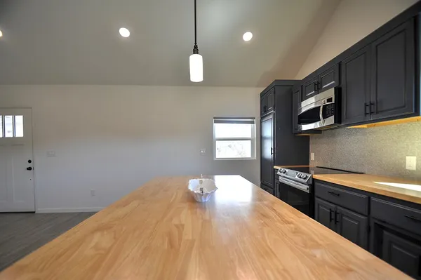 a kitchen with stainless steel appliances granite countertop a stove a sink and a microwave