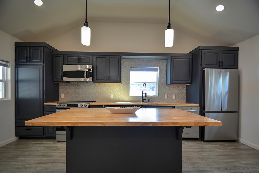 110 A Garner Road Kerrville, TX 78028 - Photo 9 of 46 a kitchen with kitchen island a sink refrigerator and microwave