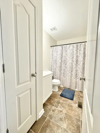 a bath room with a toilet and a shower