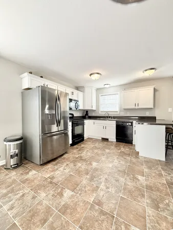 a kitchen with granite countertop a refrigerator and a stove top oven