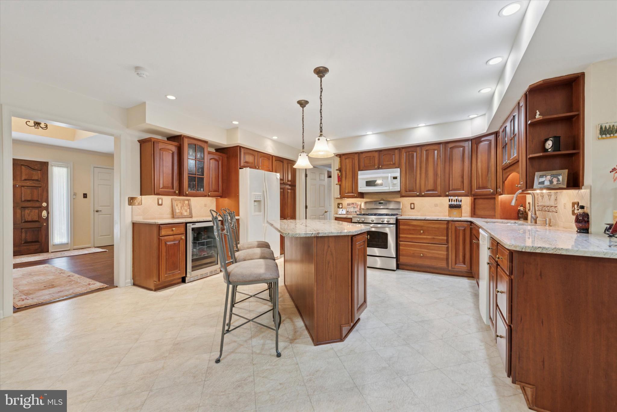856 Monteith Drive Wayne, PA 19087 - Photo 11 of 35 a kitchen with stainless steel appliances kitchen island granite countertop a refrigerator a stove top oven a sink dishwasher and white cabinets with wooden floor
