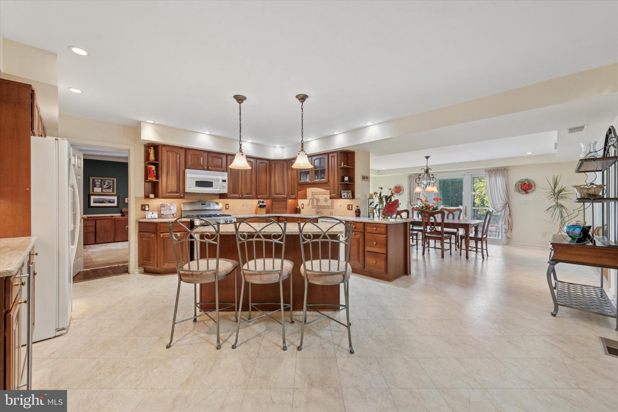 856 Monteith Drive Wayne, PA 19087 - Photo 12 of 35 a kitchen with stainless steel appliances kitchen island granite countertop a table and chairs in it