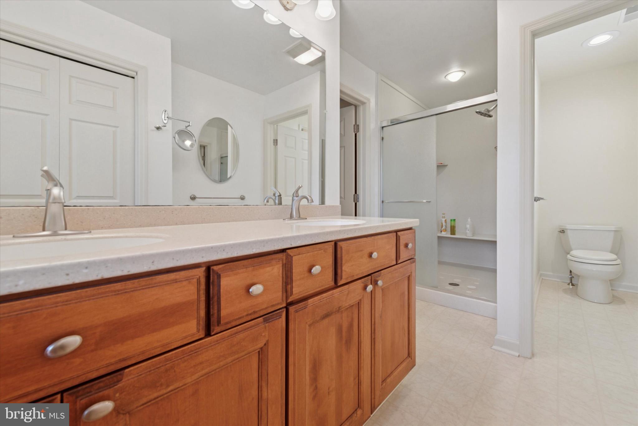 856 Monteith Drive Wayne, PA 19087 - Photo 30 of 35 a bathroom with a double vanity sink a toilet and a mirror