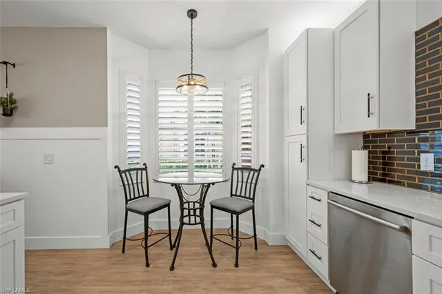 a view of a kitchen with dining table chairs and entryway