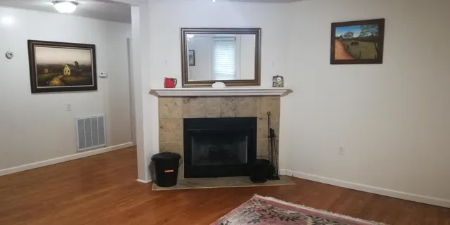 a living room with a fireplace and a wooden floor