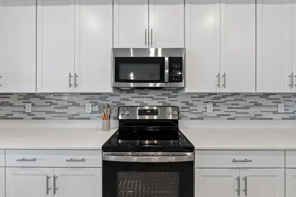a kitchen with a dining table chairs refrigerator and microwave