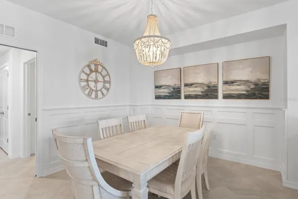 a living room with furniture a chandelier and a dining room