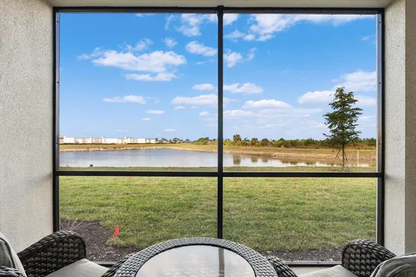 a kitchen with stainless steel appliances kitchen island granite countertop a dining table chairs and white cabinets