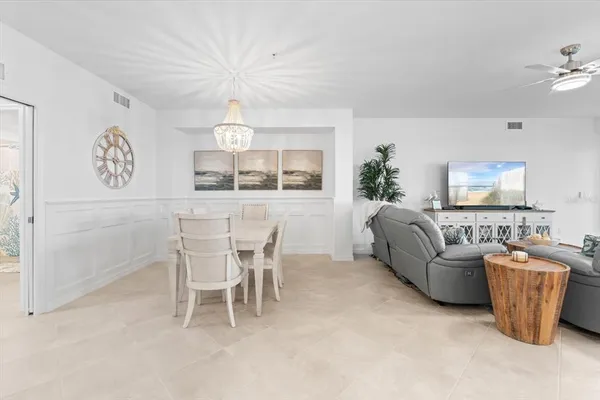 a kitchen with a sink a refrigerator and chairs