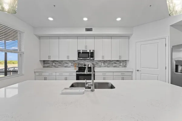 a kitchen with stainless steel appliances a refrigerator and cabinets