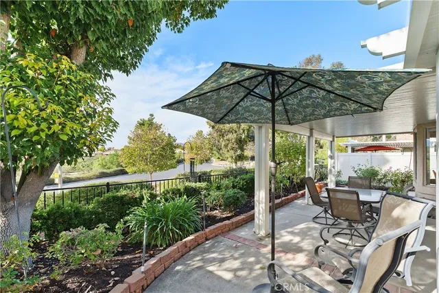 a view of a patio with table and chairs under an umbrella