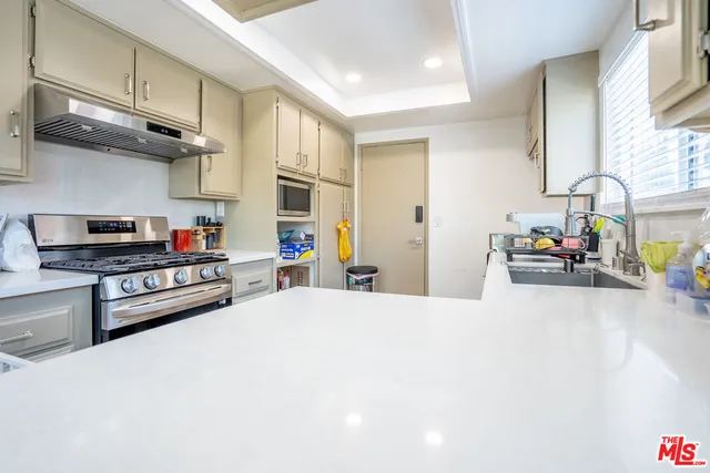 a kitchen with stainless steel appliances kitchen island granite countertop a refrigerator and a stove top oven
