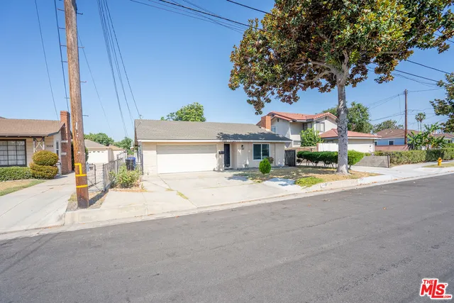 a view of a house with a patio and a yard