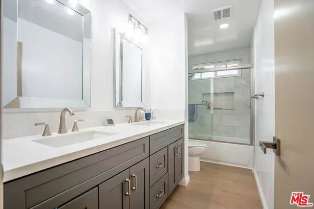 a bathroom with a double vanity sink mirror and toilet