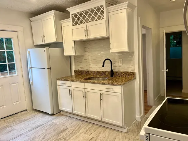 a kitchen with a refrigerator sink and cabinets
