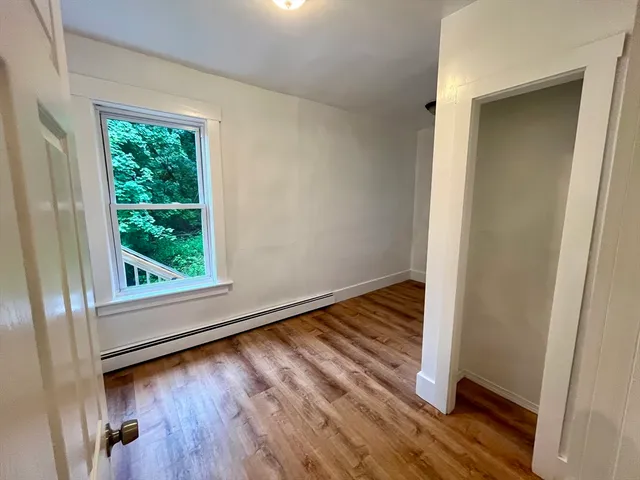 a view of a room with wooden floor and window